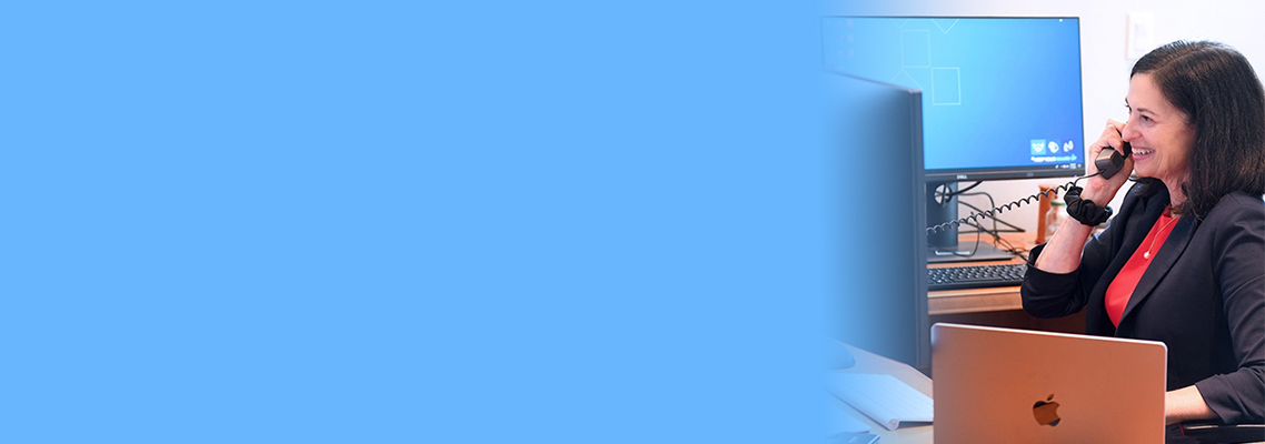 Judy Aschner at desk on phone